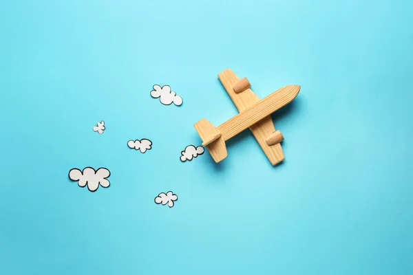 Avião de brinquedo e nuvens de papel no fundo de cor. Conceito de viagem — Fotografia de Stock