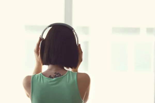 Young woman listening to music at home — Stock Photo, Image