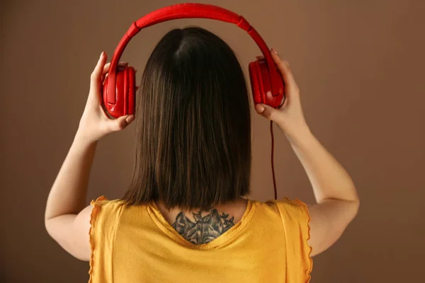 Mujer joven escuchando música sobre fondo de color — Foto de Stock