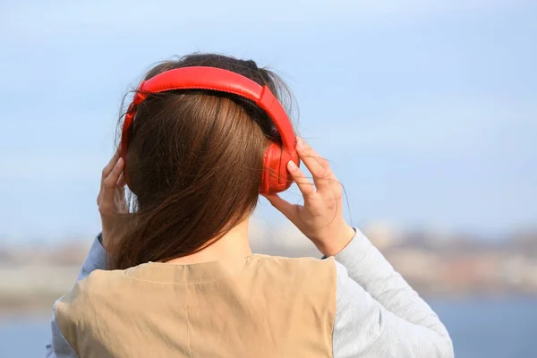 Jovem mulher ouvindo música ao ar livre — Fotografia de Stock