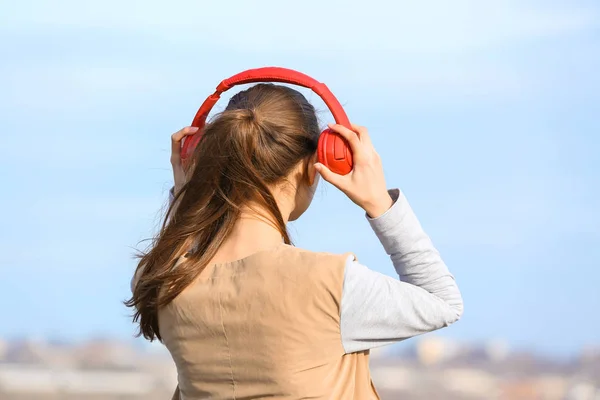 Young woman listening to music outdoors — Stock Photo, Image