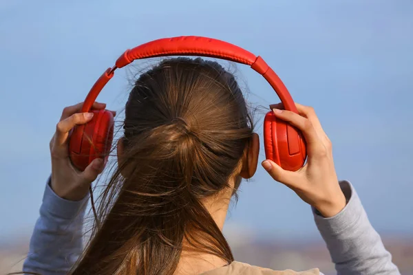 Jovem mulher ouvindo música ao ar livre — Fotografia de Stock