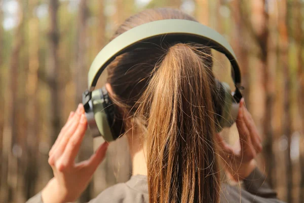 Jonge vrouw, luisteren naar muziek in bos — Stockfoto