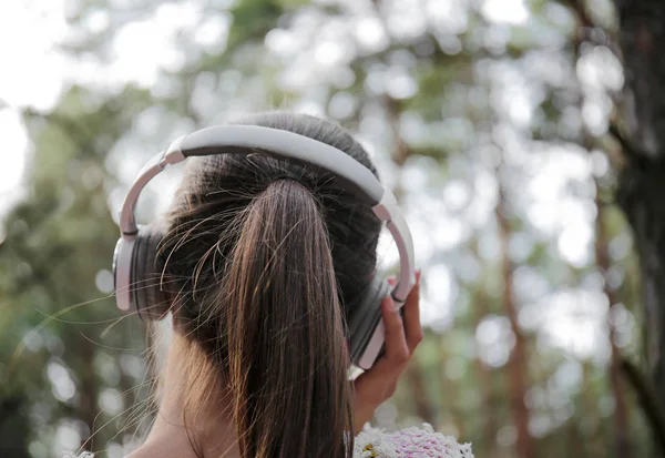 Młoda kobieta, słuchanie muzyki w lesie — Zdjęcie stockowe