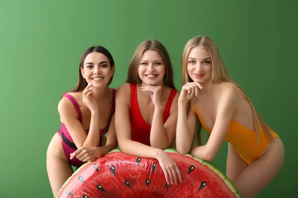 Piękne młode kobiety w garniturach kąpielowych na kolorowym tle — Zdjęcie stockowe