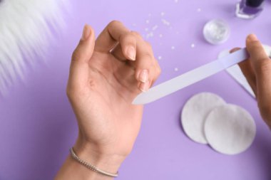 Renkli arka planda manikür yapan kadın