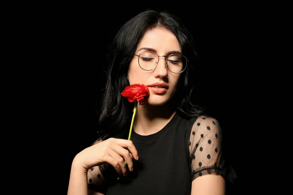 Retrato de mulher bonita com flor no fundo escuro — Fotografia de Stock