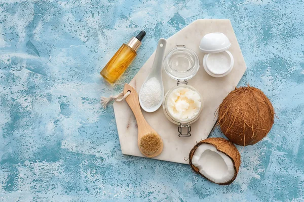 Composição com óleo de coco, cosméticos e escova sobre fundo de cor — Fotografia de Stock