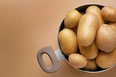 Renk arka planda çiğ patates ile pot