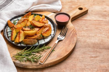 Ahşap masada lezzetli pişmiş patates ve sos ile plaka