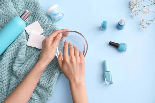 Mujer haciendo manicura sobre fondo de color — Foto de Stock