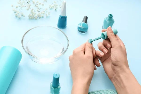 Woman doing manicure on color background — Stock Photo, Image