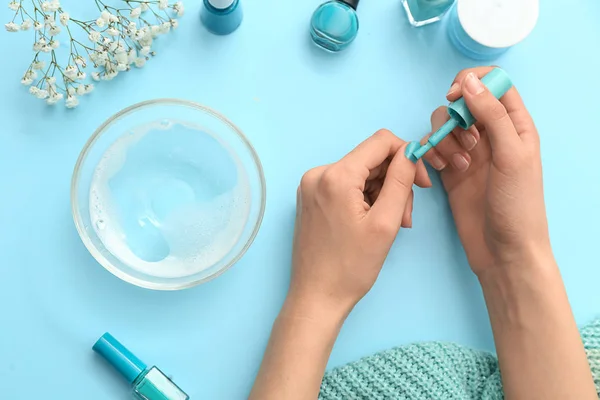 Woman doing manicure on color background — Stock Photo, Image