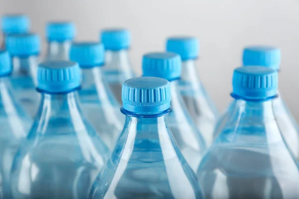 Bottles of water on light background, closeup — Stock Photo, Image