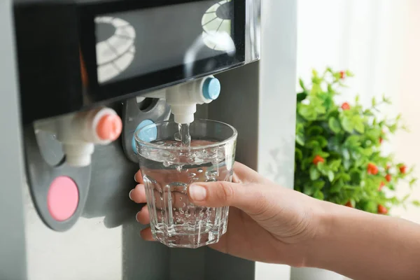 Woman pouring water from cooler into glass, closeup — Stock Photo, Image