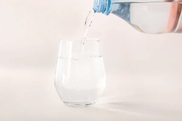 白い背景にガラスに水を注ぐ — ストック写真