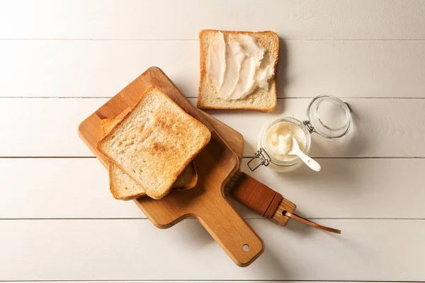 Óleo de coco com saboroso pão torrado na mesa branca — Fotografia de Stock