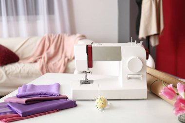 Atölyede terzi işyerindeki kumaş ve aksesuarlarla dikiş makinesi