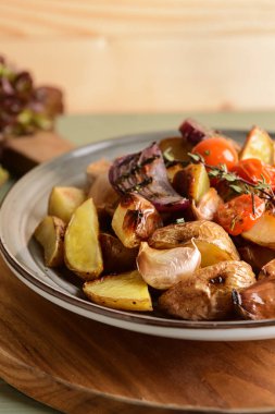 Ahşap tahta üzerinde lezzetli pişmiş patates ile plaka