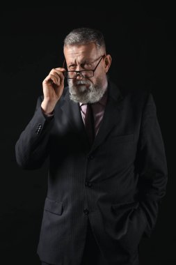 Koyu arka plan üzerinde yakışıklı olgun işadamı