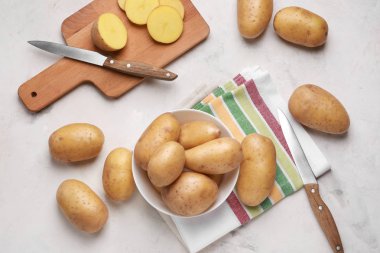 Hafif masada bıçak ve kesme tahtası ile çiğ patates
