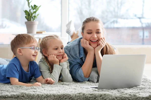 Junge Mutter mit kleinen Kindern schaut Cartoons zu Hause — Stockfoto