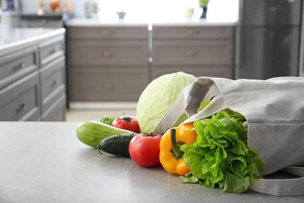 Eco bag with fresh vegetables on table in kitchen — Stock Photo, Image