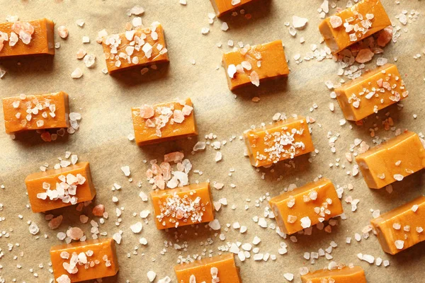 Parşömen üzerinde lezzetli tuzlu karamel şekerler — Stok fotoğraf