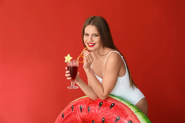 Beautiful young woman with inflatable ring and cocktail on color background — Stock Photo, Image