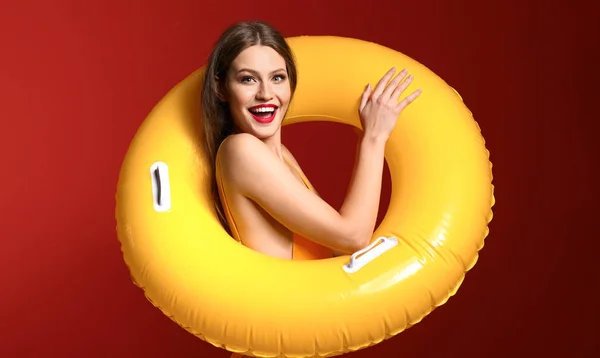 Beautiful young woman with inflatable ring on color background — Stock Photo, Image