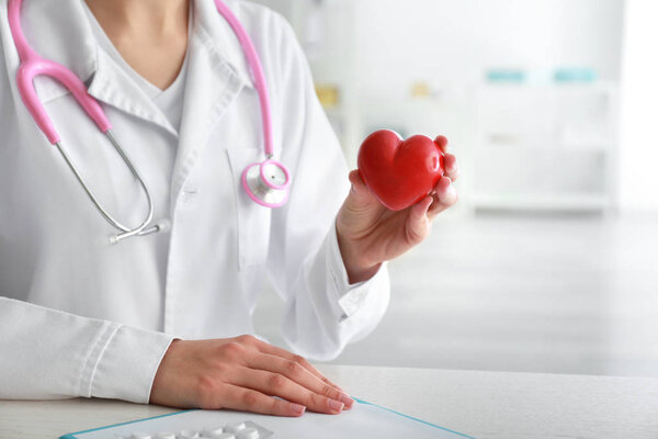 Cardiologist with red heart in clinic