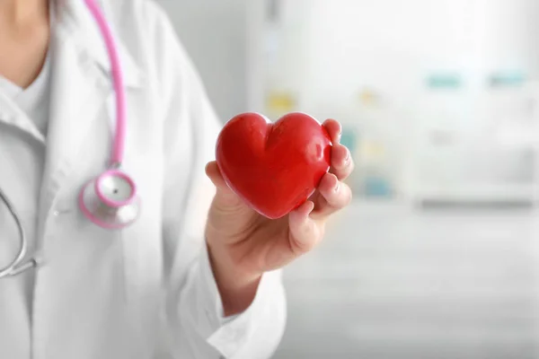 Cardiologist with red heart in clinic — Stock Photo, Image