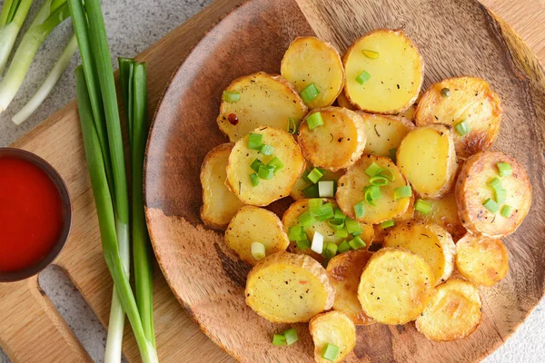 Ahşap tahta üzerinde lezzetli pişmiş patates ve soğan ile plaka — Stok fotoğraf