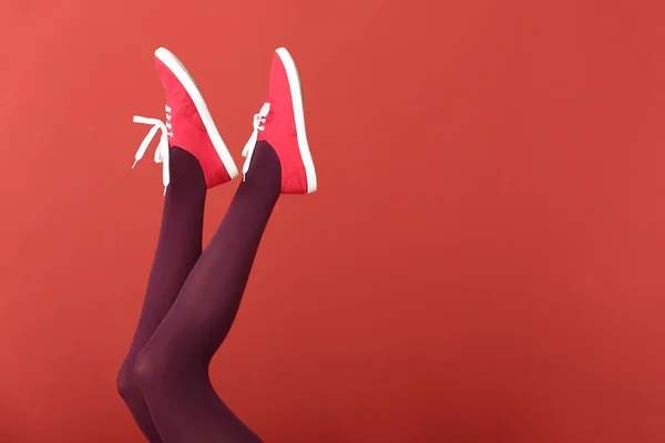 Giovane donna in scarpe alla moda su sfondo di colore — Foto Stock