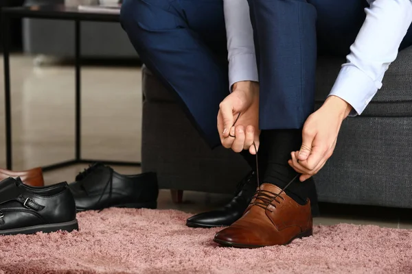 Young man changing his shoes in room — Stock Photo, Image