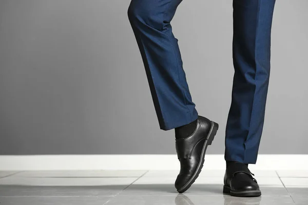 Hombre joven en zapatos elegantes cerca de la pared de color —  Fotos de Stock