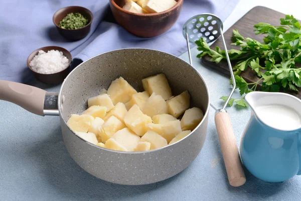 Zubereitung von leckerem Kartoffelpüree auf farbigem Hintergrund — Stockfoto