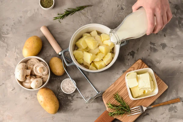 Woman preparing tasty mashed potato at table