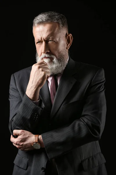 Handsome mature businessman on dark background — Stock Photo, Image