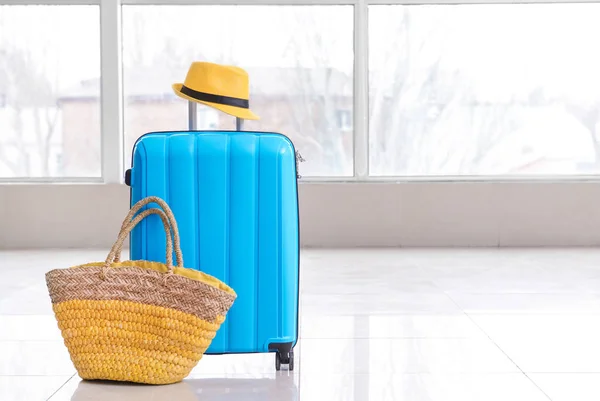 Packed suitcase, beach bag and hat in room. Travel concept