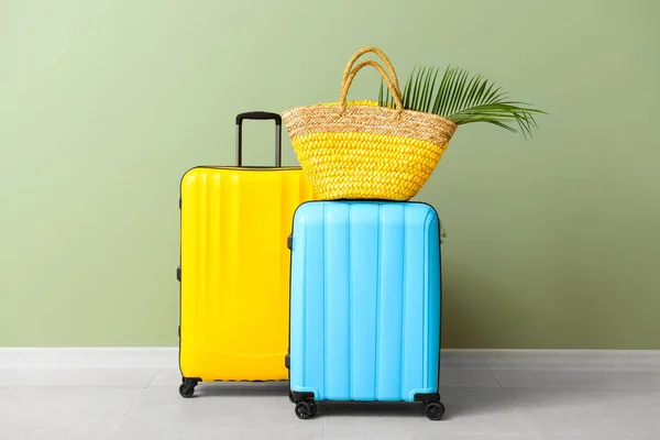 Maletas embaladas y bolsa de playa cerca de la pared de color —  Fotos de Stock