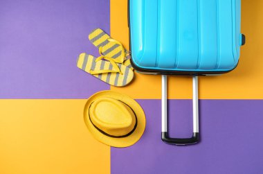 Bavul, parmak arası terlik ve renk arka plan üzerinde şapka. Seyahat konsepti