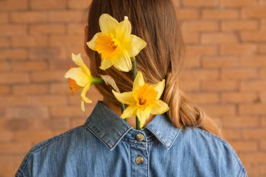 Tuğla duvara karşı güzel nergis ile kadın