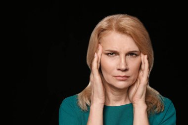 Karanlık arka plan üzerinde baş ağrısı muzdarip Olgun kadın