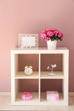 Raf ünitesinde güzel çiçeklenme Azalea ve dekor ile pot