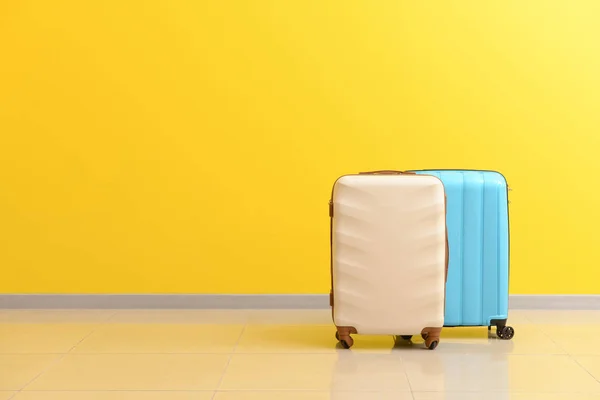Packed suitcases near color wall — Stock Photo, Image