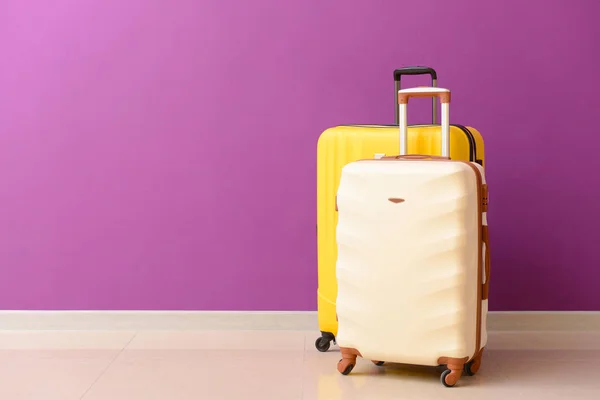 Csomagolt bőröndök közelében színes fal — Stock Fotó