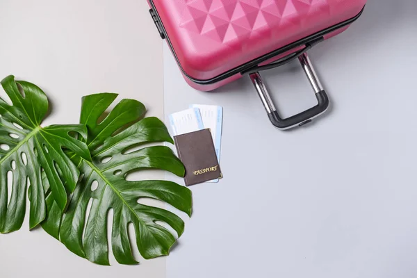 Suitcase, tropical leaves and documents on grey background. Travel concept — Stock Photo, Image