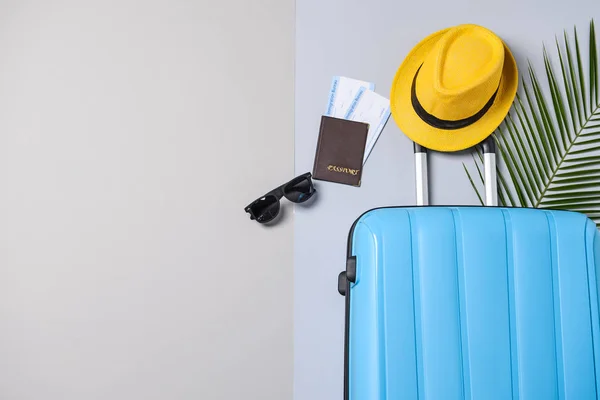 Valise, chapeau, lunettes de soleil et documents sur fond gris. Concept de voyage — Photo