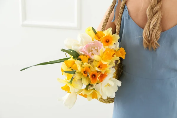 Woman with bag and bouquet of beautiful flowers on white background — Stock Photo, Image